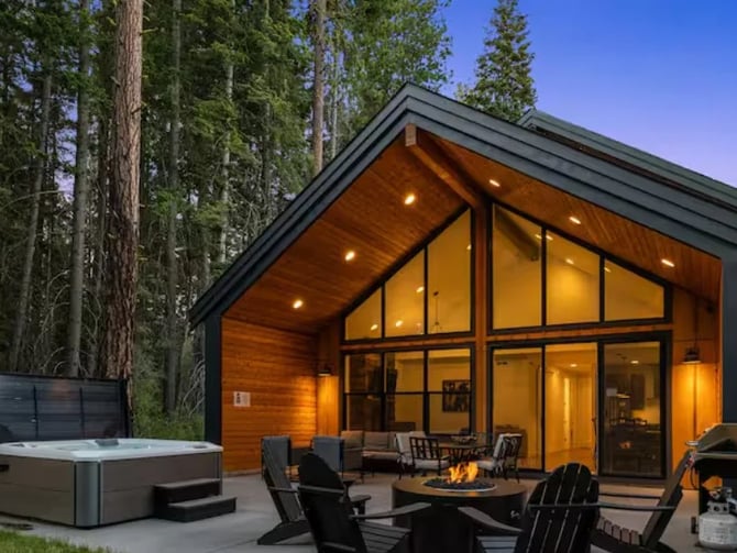 Wildwood Cabin exterior at dusk with hot tub and fire pit seating